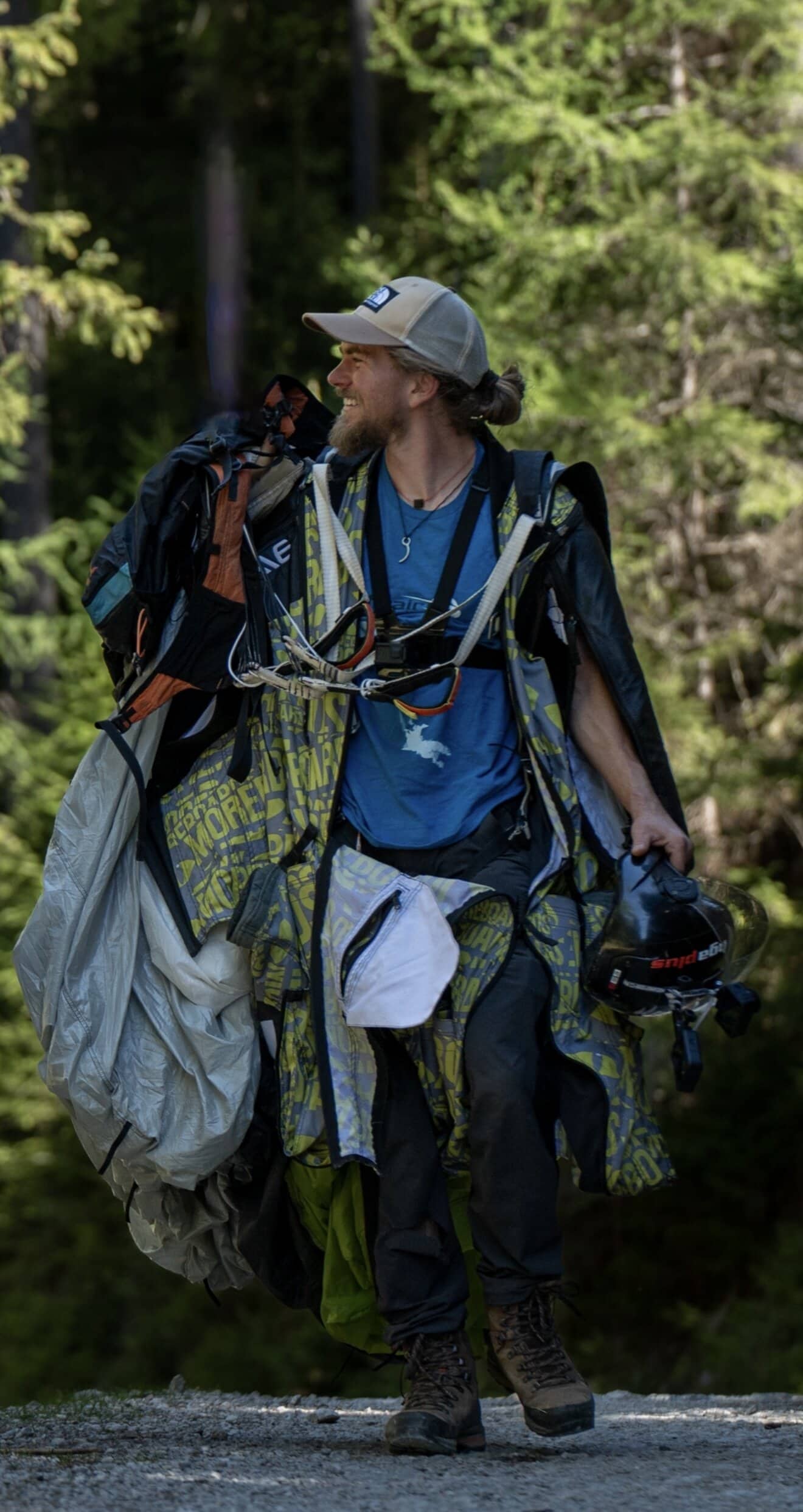 Lukas Loibl trägt Fallschirmausrüstung auf einem Waldweg
