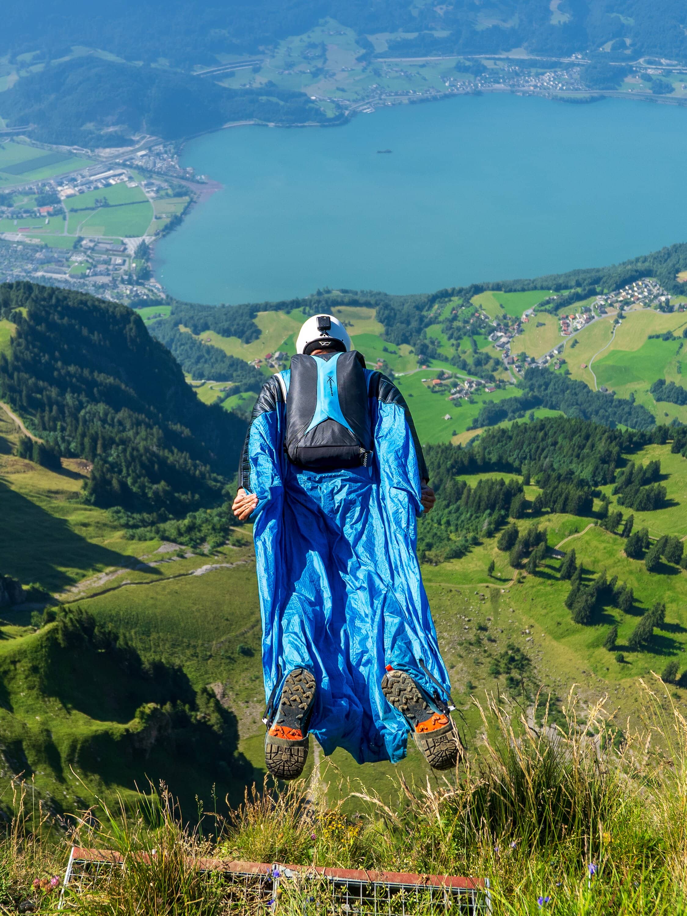 Marcel Geser steht im Wingsuit auf einem grasigen Berghang