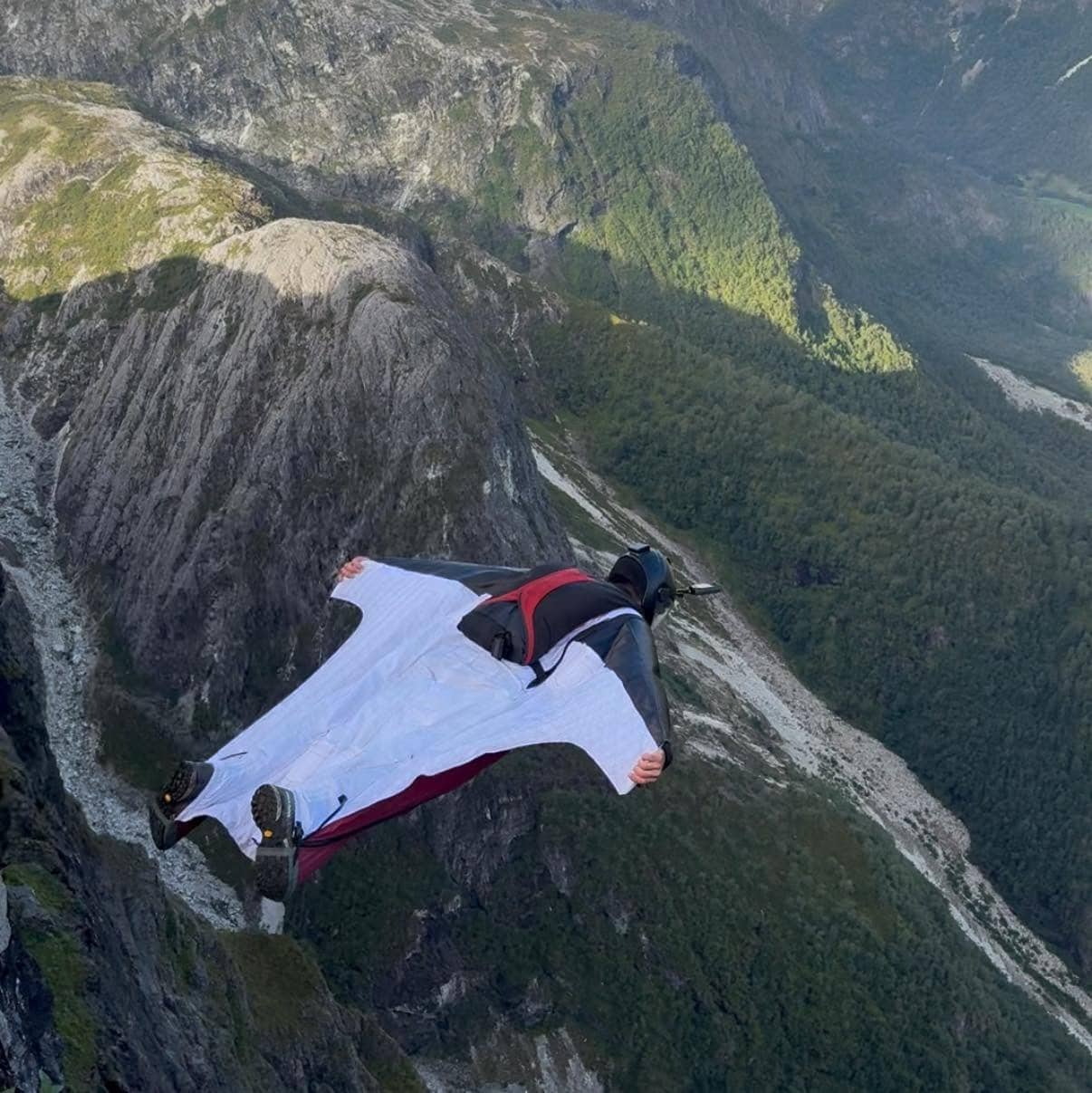 Niclas Strohmeier winkt neben einer Schweizer Fahne auf einem Berggrat