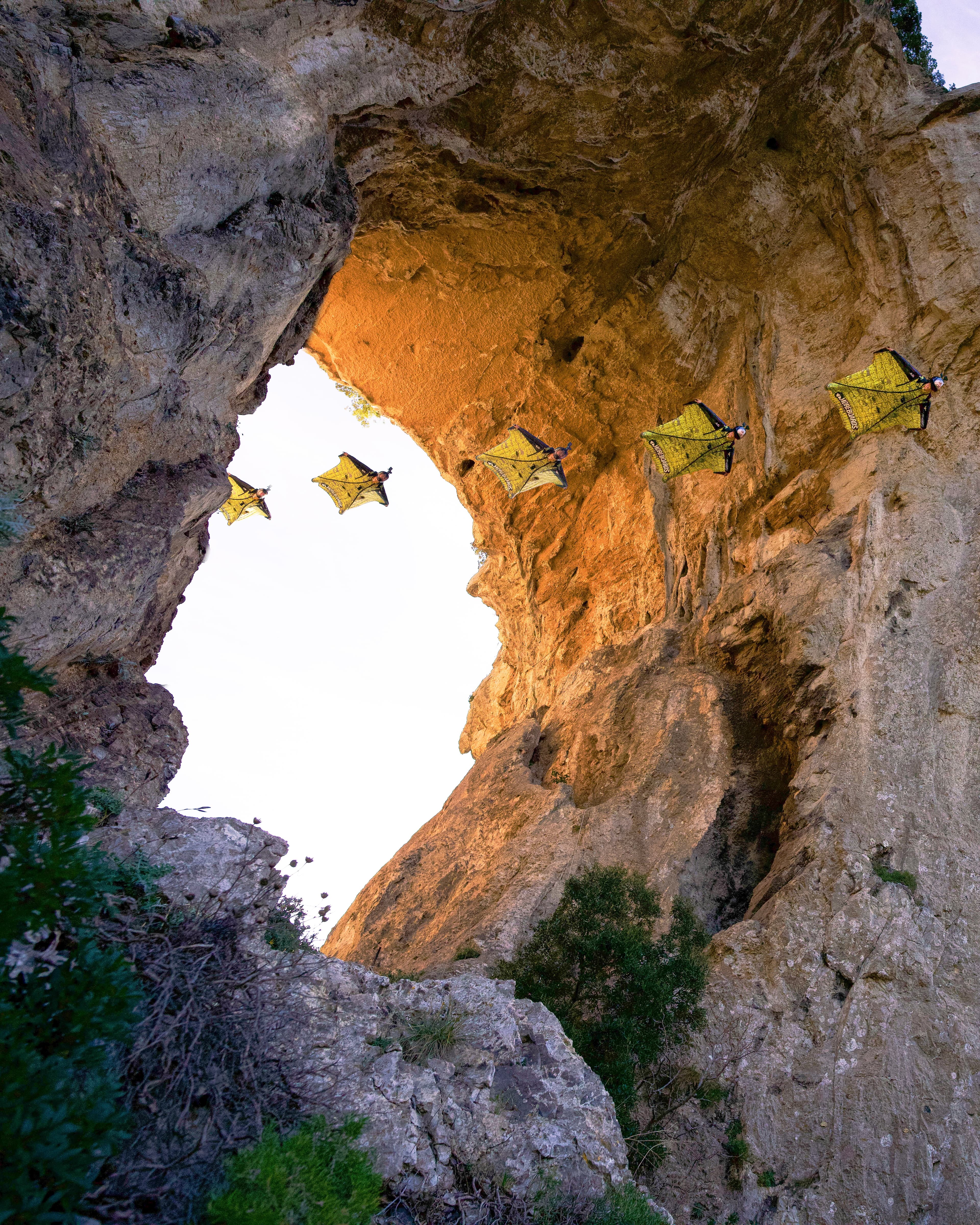 Lukas Loibl fliegt im Wingsuit nahe an einem steilen alpinen Felsentor