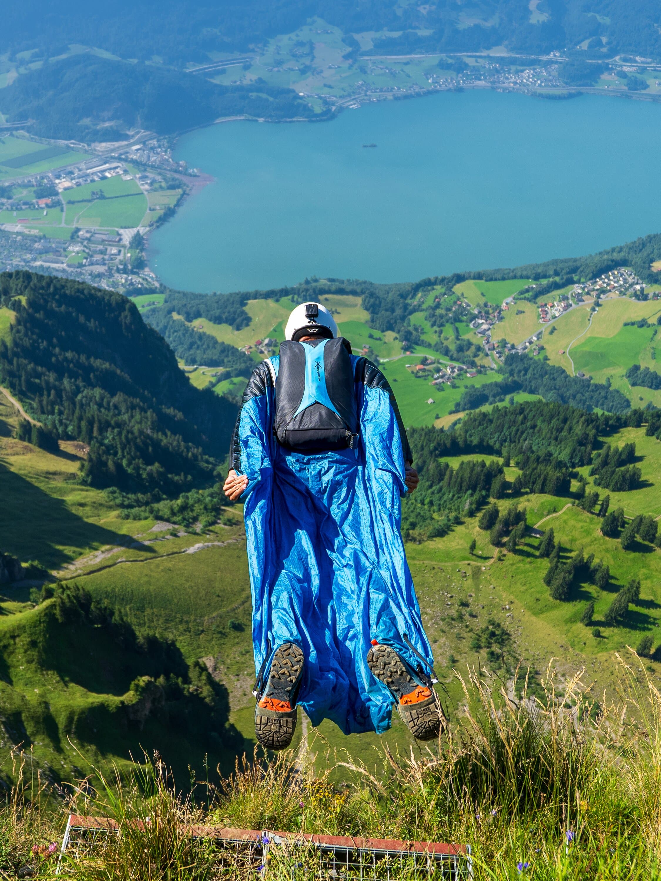 Marcel Geser standing in a wingsuit on a grassy hillside