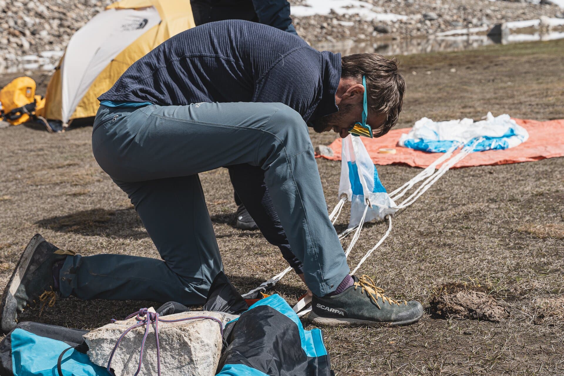 Tim Howell packing parachute gear on the ground