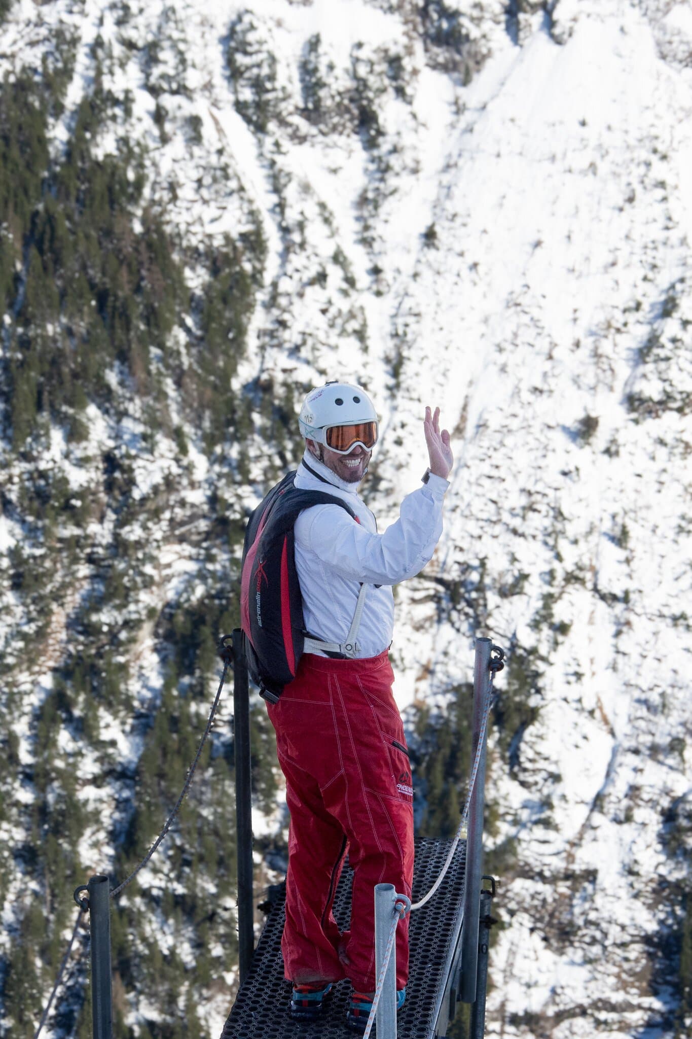 Person in red trousers standing among snowy trees