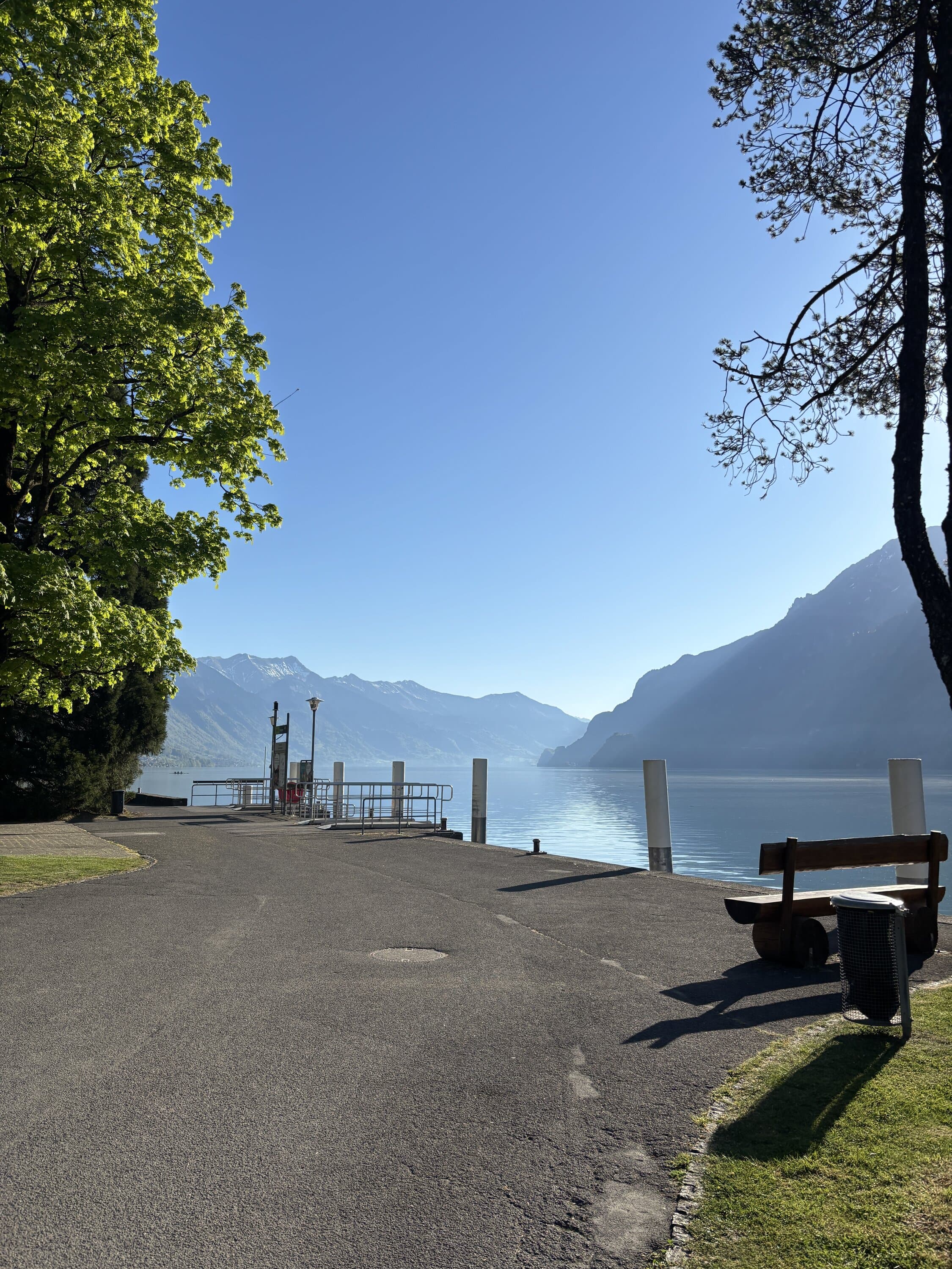 Lakeside path with benches and mountains across the water