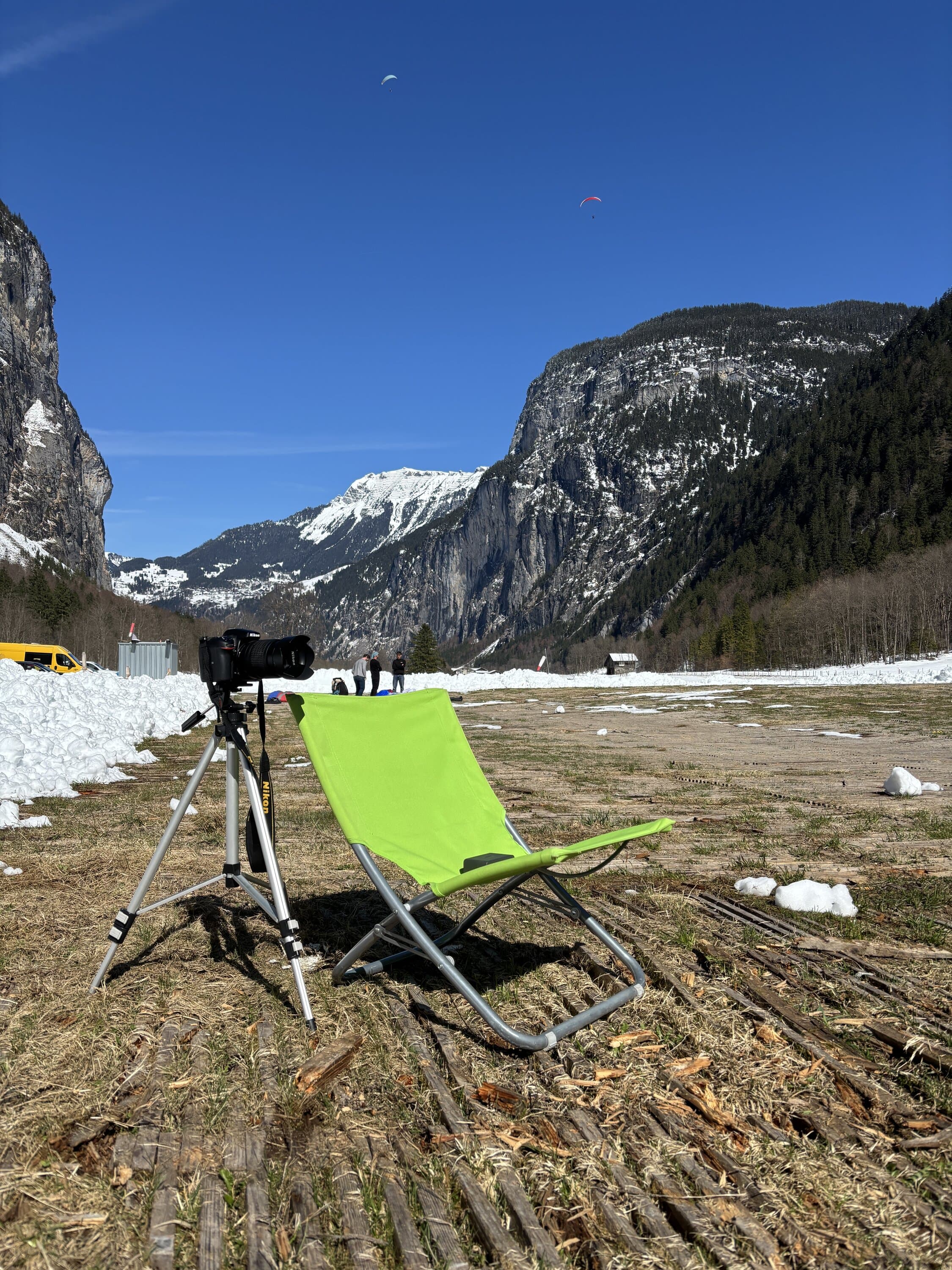 Folding chair and camera tripod set up in an alpine meadow
