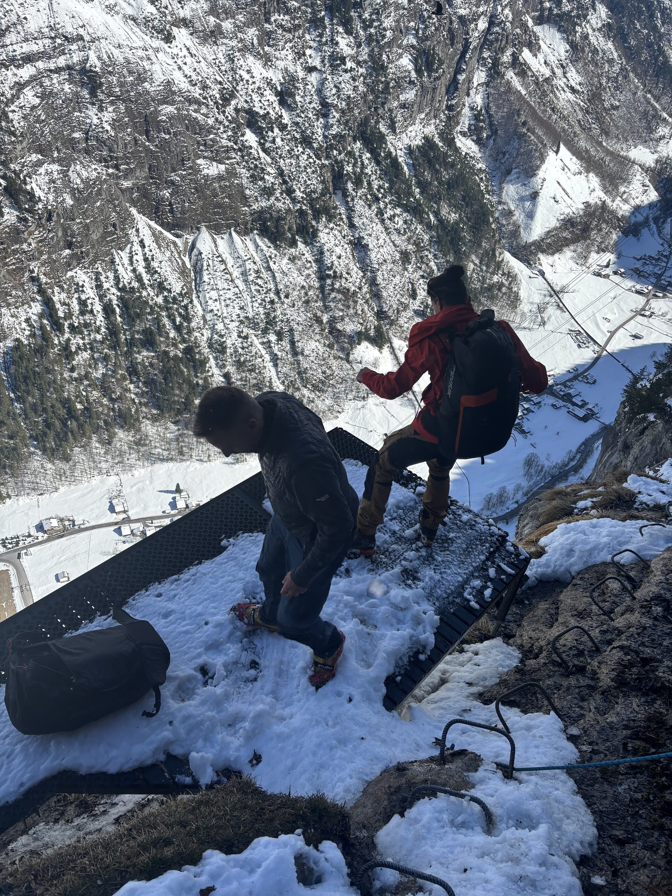 Two people with camera gear on snowy rocks