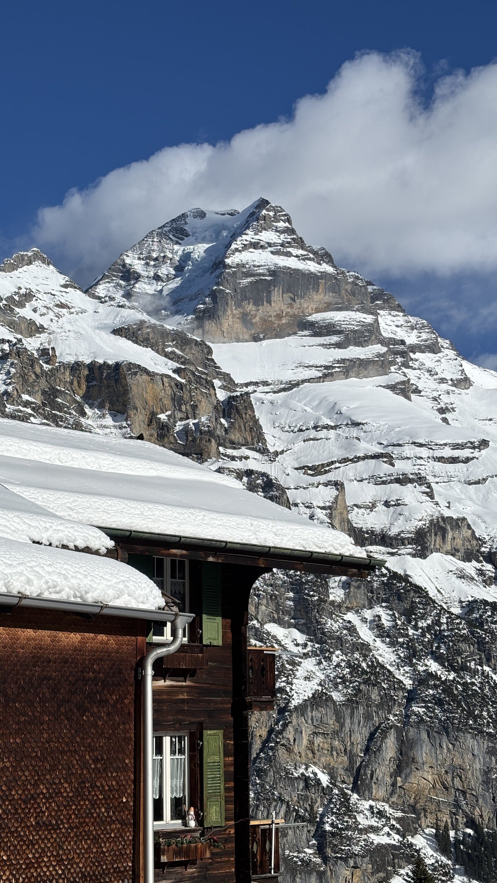 Mountain hut below snow-covered peaks